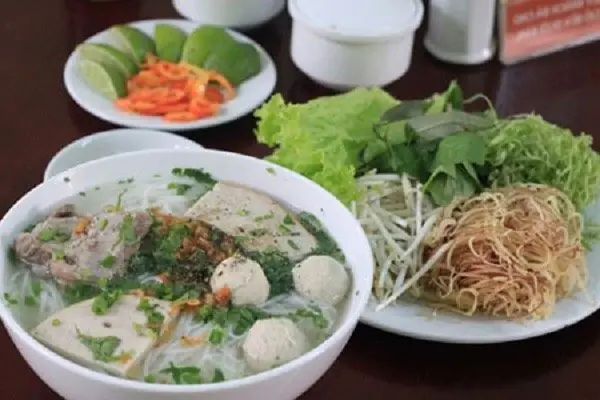 Vietnamese noodle soup with herbs and rice noodles