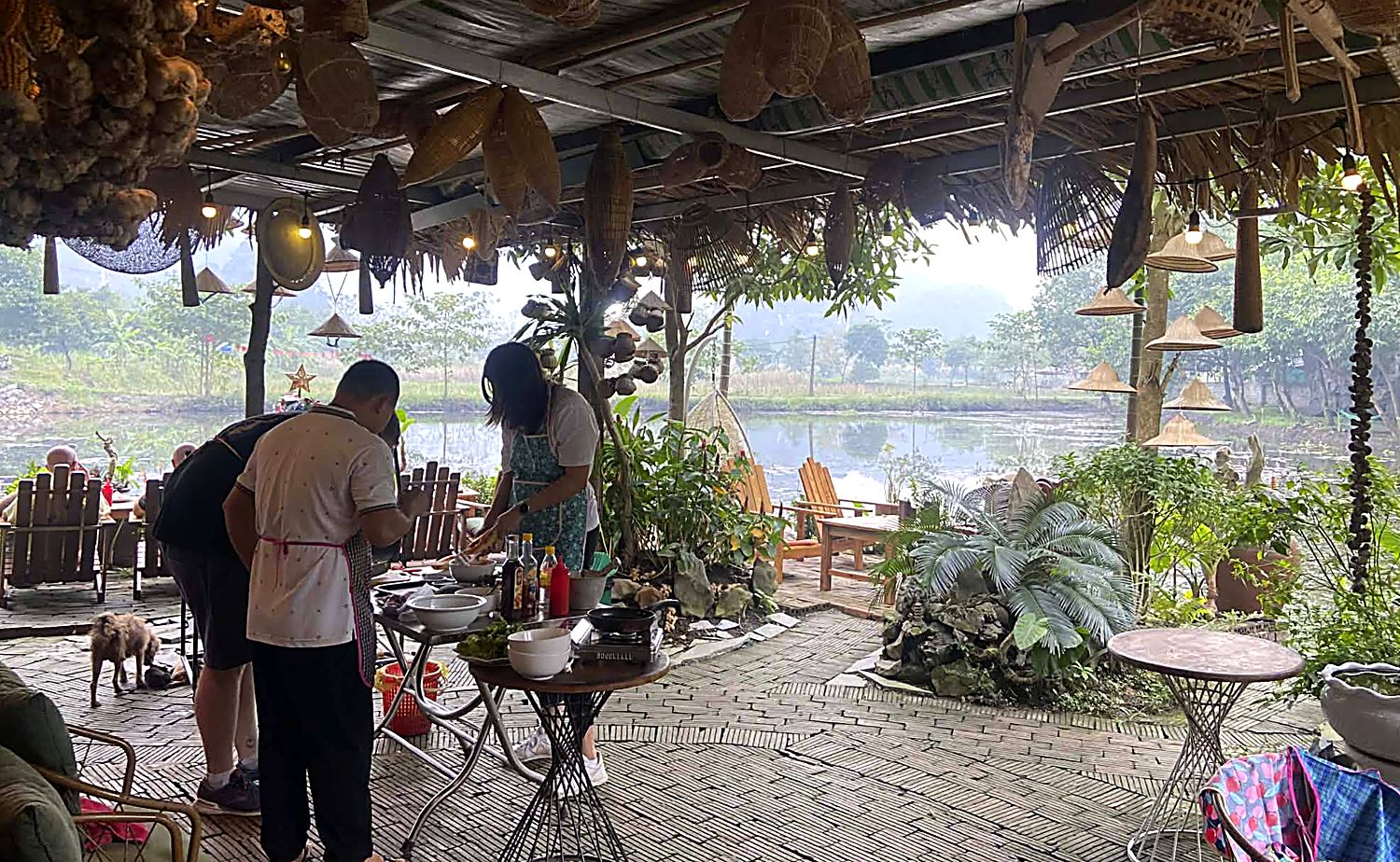 A cooking class under cover by the water in Tam Coc while it rains outside